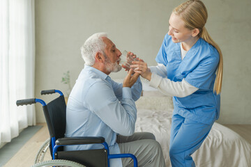 Help support healthcare water balance. Nurse giving glass water for old man patient in wheelchair....