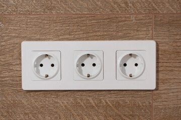 Three white electrical outlets on the wall