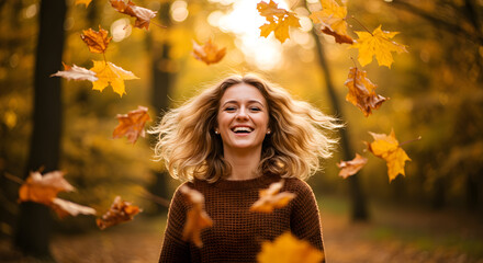 A woman with blonde hair smiling in a forest with falling autumn leaves around her face and head area