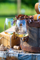 Glasses of wine stand on a wooden wine barrel, wine corks