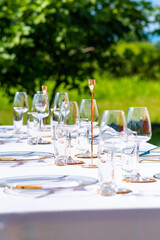 Banquet table set for an outdoor wedding ceremony, white tablecloth
