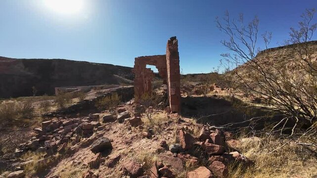 Virgin River Gorge- Hurricane, Utah, USA - February 10, 2025: Aerial-FPV-First Person view Flying through desert ruins of the Stormont Silver Mills along the bank of the Virgin River under a bright bl