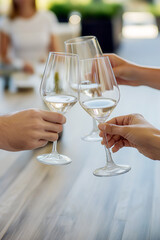 Obraz premium close up of toast, people clinking glasses of white wine at party