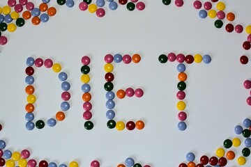 Candy diet concept. Word diet made from round chocolate candies on white background. Unhealthy diet