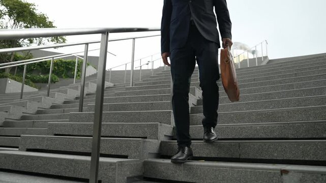 Closeup of skilled manager walking down stair with a bag and return to home. Closeup of project manager leg getting fired and walk to dormitory. Investor with untidy suit. Focus on leg. Exultant.