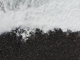 Aerial View of Waves Crashing on Pebble Beach