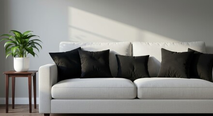 Modern Living Room Sofa with Black Pillows - Stylish white sofa with black pillows, complemented by a green plant on a side table, bathed in sunlight. Minimalist interior design