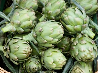 Fototapeta premium Farmers market basket displaying fresh green artichokes with purple tinged leaves, showcasing seasonal organic produce ready for cooking