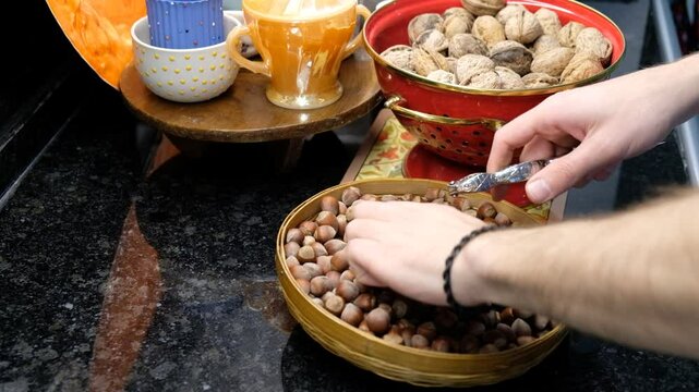 Nut Cracking in the Kitchen &ndash; Close-Up of Hazelnuts and Cracker on the Counter