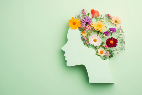 World mental health day concept. Paper human head symbol and flowers on blue background 
