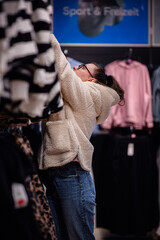 Woman Shopping for Jackets in Clothing Store