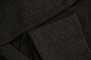 Fototapeta premium Dark grey sweater texture as a background. Knitted pattern.