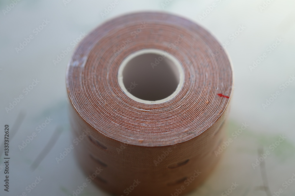 Poster a roll of tape sits atop a table, ready for use.