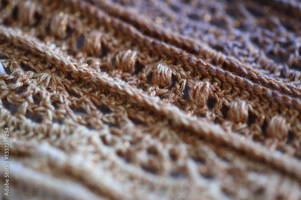 Aufkleber a close-up view of a knitted scarf lying on a table, with intricate stitches and texture.