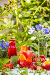 Refreshing strawberry and orange summer drink with fresh mint and berries