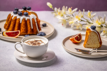Delicious gugelhupf cake with blueberries, blood orange, and cappuccino for a relaxing breakfast