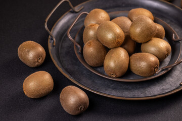 Fresh kiwi fruits displayed on a dark metal tray