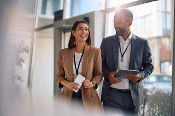 Happy corporate manager talking while walking in office.