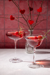 Romantic valentine's day cocktails with raspberries and rosemary on a table