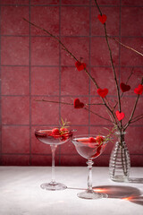 Two elegant cocktails celebrating valentine's day with raspberries and rosemary
