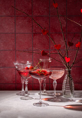 Romantic valentine's day cocktails with raspberries and rosemary on red background