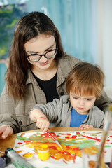 Mother and son painting together in their room