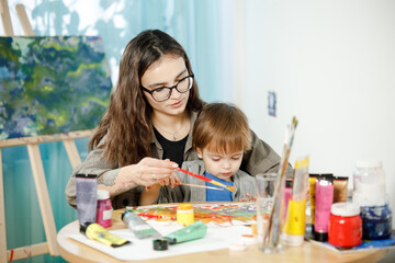 Fototapeta premium Mother and son painting together in their room