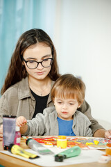Mother and son painting together in their room