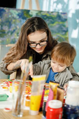 Mother and son painting together in their room