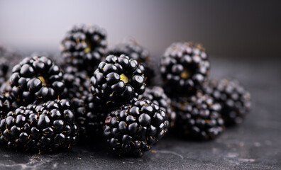 Blackberry closeup, blackberries background. Heap of Fresh Ripe organic black berries over gray backdrop, close-up. Macro shot. Market. Vegan food 