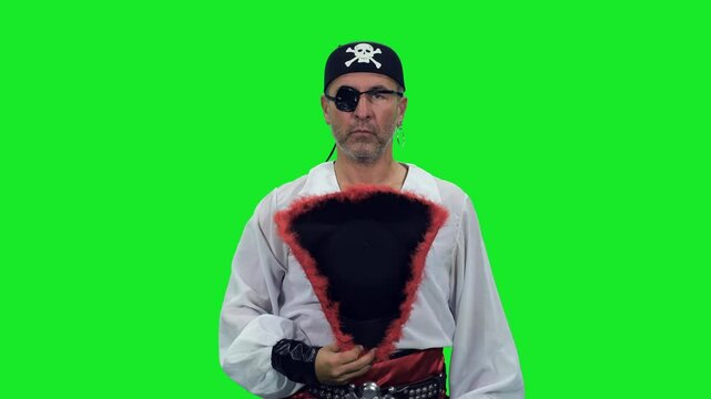 Rugged pirate with an eye patch takes off his hat and looks at the camera on green chroma key background, 4k pre-keyed footage