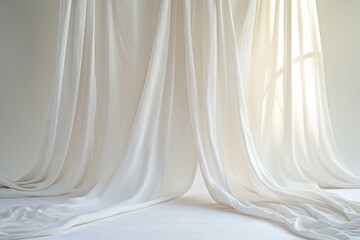 Soft, white drapes billow over a pristine studio backdrop, sunlight filtering through a window