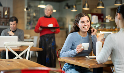 Two women talking over cup of coffee in a cafe