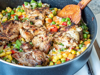 chicken, rice and vegetables mix in a pan