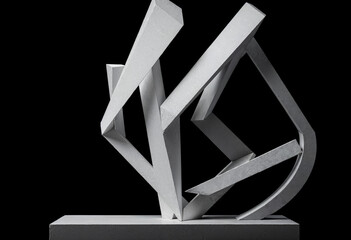 Abstract modern sculpture featuring geometric shapes and sharp angles on a black background, showcasing creativity and minimalist design.