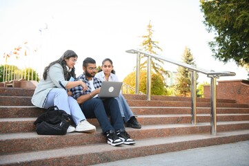 group of young students checking exam results or waiting for project approval on laptop at collage...