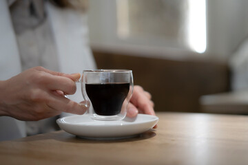 Businesswoman holding a cup of coffee in a modern office during break time
