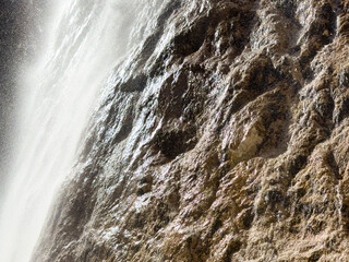 close up of waterfall flowing down. rocky surface. stone texture. wet stone. natural texture background. abstract background. ecology concepts