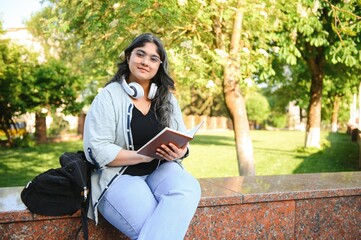 Portrait of a cheerful smart student girl studying with books. Indian student educational young...