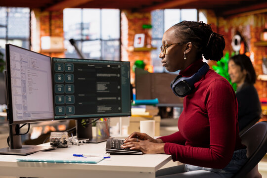 IT engineer in startup office using large language model on computer to get help with coding project. IT expert interacting with AI LLM chatbot on PC in software development business company