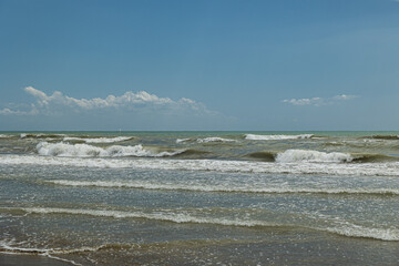 vista panoramica che si estende dalla vicina costa del Veneto e si affaccia sul mare Adriatico, guardando verso il lontano orizzonte, con mare mosso, di giorno, in estate e cielo sereno
