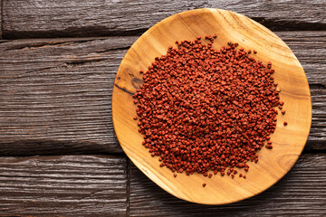 Organic red annatto seeds in the bowl - Bixa Orellana