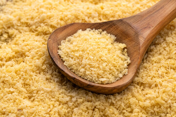 Fresh crispy yellow panko crumbs on a wooden spoon