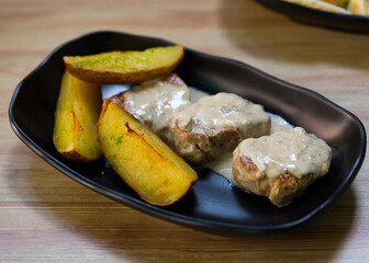Prepared sirloin medallion with mushrooms sauce and potato at plate
