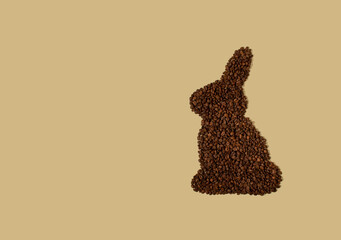 Easter bunnie made of a coffee beans on a light beige background with copy space. Easter minimalism.