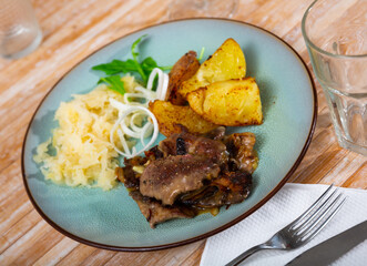 Appetizing fried rabbit liver with potatoes and grated vegetables