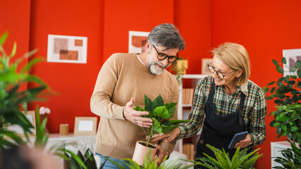 couple take care of plants and follow instructions from cellphone