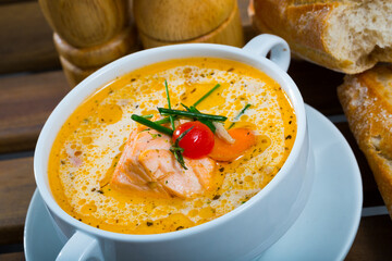 Dish of Norwegian cuisine - cream salmon soup with carrots and potatoes