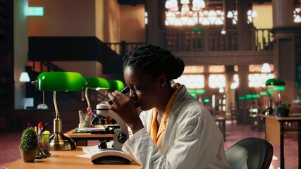 University scholar focuses on examining chemical processes and microorganisms for medical science career. Woman studying in the library to support her educational development. Camera A.