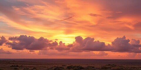 Fototapeta premium Soft pastel clouds drift across a sunrise sky, textured landscape visible below, view, background